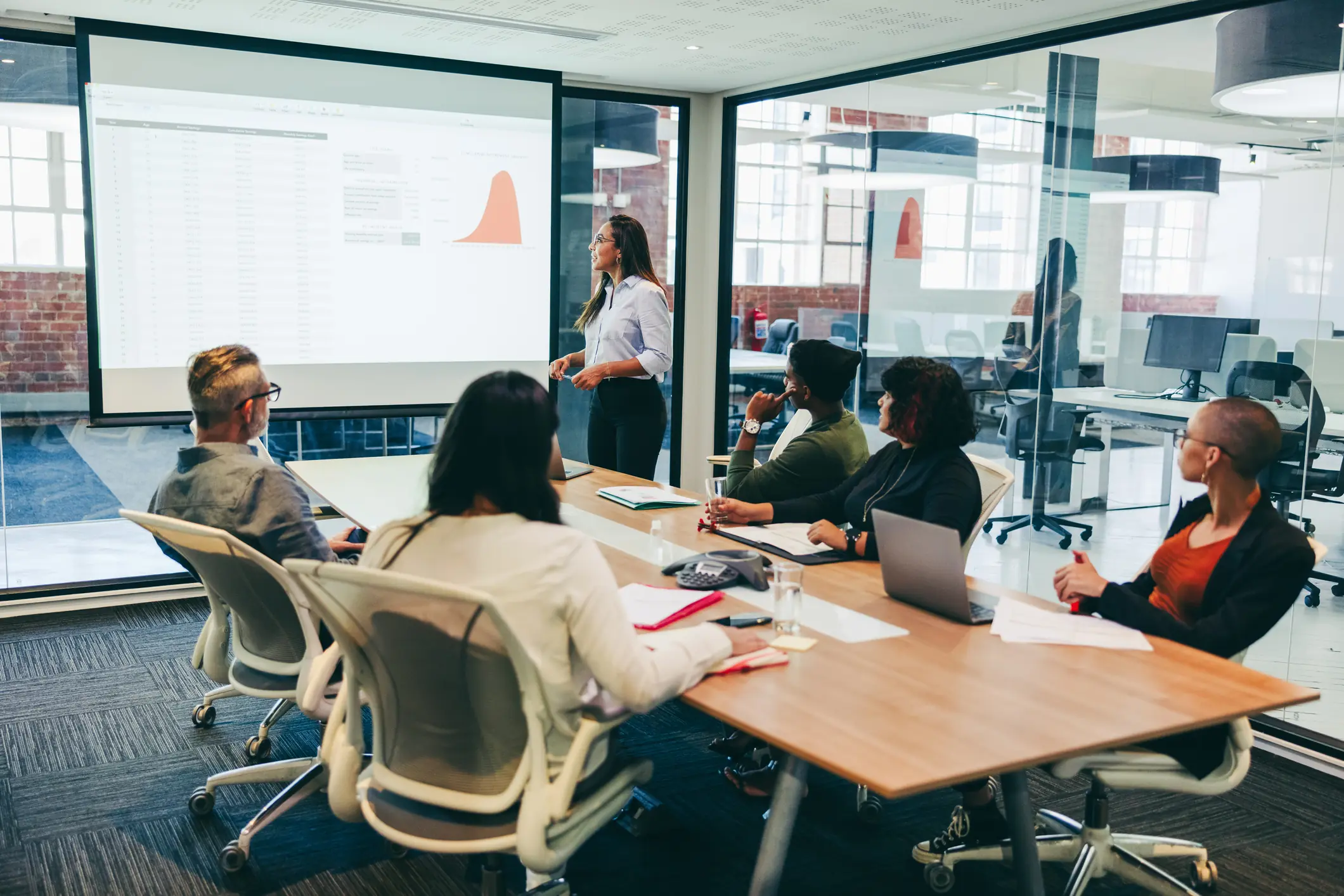 Woman presenting a room of business people CRF's technology solutions