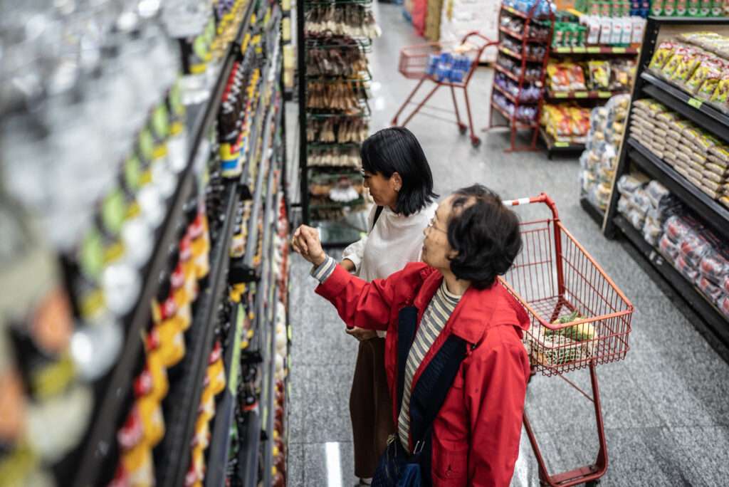 Mother and daughter buying soy sauce in a supermarket
