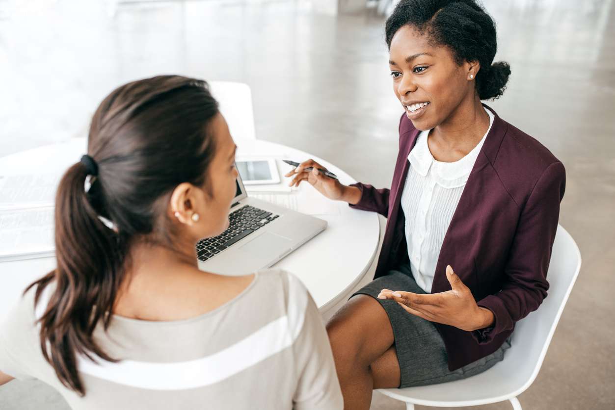 two women discussing plans in business meeting