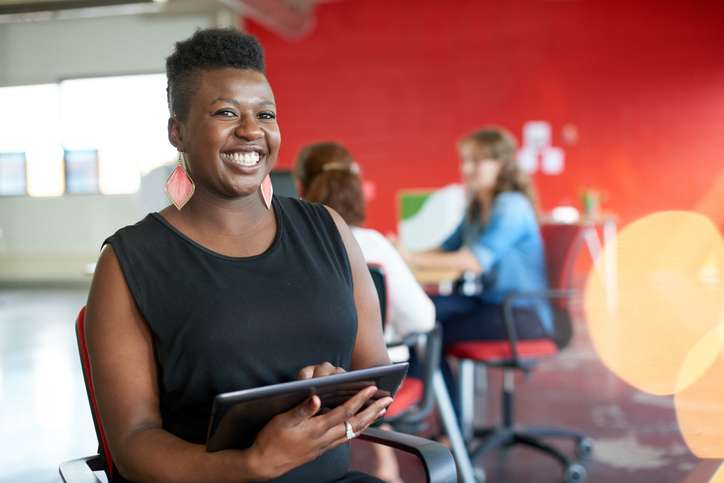 woman smiling holding ipad